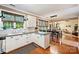 Open-concept kitchen featuring white cabinets, granite countertops, and hardwood floors at 14203 Queens Carriage Pl, Charlotte, NC 28278
