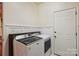 Functional laundry room featuring modern washer and dryer set and a door to the exterior at 14203 Queens Carriage Pl, Charlotte, NC 28278