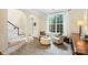 Bright living room with large windows, neutral decor, hardwood floors leading to the front door and stairs at 14203 Queens Carriage Pl, Charlotte, NC 28278