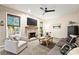 Cozy living room with a brick fireplace, ceiling fan, plush seating, and bright windows with natural light at 14203 Queens Carriage Pl, Charlotte, NC 28278