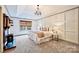 A beautifully staged primary bedroom with a decorative fireplace and a large window with natural light at 14203 Queens Carriage Pl, Charlotte, NC 28278
