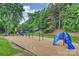 Community playground featuring swings, slides, and climbing structures surrounded by lush greenery at 14203 Queens Carriage Pl, Charlotte, NC 28278