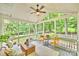 Relaxing screened-in porch with comfortable seating, ceiling fan, and a view of the wooded backyard at 14203 Queens Carriage Pl, Charlotte, NC 28278