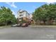 Apartment building exterior with parking spaces and mature trees at 14347 San Paolo Ln, Charlotte, NC 28277