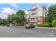Apartment building with multiple balconies, brick facade, and ample parking space under a blue sky at 14347 San Paolo Ln, Charlotte, NC 28277
