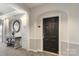 Hallway with arched entrance, decorative table with mirror, and dark front door marked '14307' at 14347 San Paolo Ln, Charlotte, NC 28277