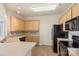 Bright kitchen with wood cabinets, black appliances, tile backsplash, and light countertops at 14347 San Paolo Ln, Charlotte, NC 28277
