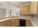 Bright kitchen with wood cabinets, black appliances, tile backsplash, and light countertops overlooking room at 14347 San Paolo Ln, Charlotte, NC 28277
