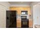 Kitchen features wooden cabinets, black appliances, tile backsplash, and light countertops at 14347 San Paolo Ln, Charlotte, NC 28277