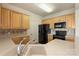 Bright kitchen with wood cabinets, black appliances, tile backsplash, and light countertops at 14347 San Paolo Ln, Charlotte, NC 28277