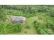 Aerial view of gray home with surrounding lawn and a mix of dense trees at 147 Buck And Doe Ln, Statesville, NC 28625