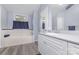 Bathroom with white vanity, bath, tile surround, laminate flooring, and a large mirror at 147 Buck And Doe Ln, Statesville, NC 28625
