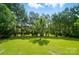 Picturesque backyard featuring green grass, beautiful trees, and peaceful surroundings at 15116 Legend Oaks Ct, Fort Mill, SC 29707