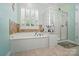 Bright bathroom with a large soaking tub, separate glass shower and window with shutters at 15116 Legend Oaks Ct, Fort Mill, SC 29707