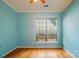 Bedroom with wood floors, blue walls, white trim and window letting in natural light at 15116 Legend Oaks Ct, Fort Mill, SC 29707