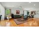 Open-concept living room featuring hardwood floors, large windows, and seamless flow into the dining area at 15116 Legend Oaks Ct, Fort Mill, SC 29707