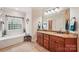 Bathroom with double sink vanity, granite countertops, and a garden tub under a large window at 1575 Williamsburg Dr, Rock Hill, SC 29732
