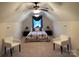 Carpeted bedroom with vaulted ceiling, ceiling fan, two chairs and a neatly arranged bed with bedside tables at 1575 Williamsburg Dr, Rock Hill, SC 29732