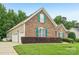 Charming brick home featuring green shutters, lush lawn, and a convenient two-car garage at 1575 Williamsburg Dr, Rock Hill, SC 29732