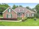 Charming brick home featuring a colorful front door, manicured lawn, and vibrant green shutters at 1575 Williamsburg Dr, Rock Hill, SC 29732