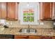 Close-up of the kitchen sink featuring granite counters and hardwood cabinets at 1575 Williamsburg Dr, Rock Hill, SC 29732