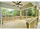 View of the covered wooden back porch with ceiling fan and view of the backyard at 1721 S New Hope Rd, Gastonia, NC 28054