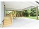 Covered back porch features wooden railings and steps to a concrete patio and yard at 1721 S New Hope Rd, Gastonia, NC 28054