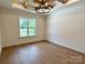 Bedroom with hardwood floors, large window, and decorative wood beam ceiling design at 1721 S New Hope Rd, Gastonia, NC 28054