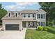 Charming brick home featuring dormer windows, attached garage, inviting front porch, and manicured lawn at 207 Spaniel Se Dr, Concord, NC 28025