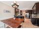 Bright, open kitchen with wooden table, dark cabinets, granite countertops and stainless appliances at 207 Spaniel Se Dr, Concord, NC 28025