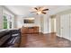 Spacious living room with hardwood floors, TV, fan and a comfortable leather couch at 207 Spaniel Se Dr, Concord, NC 28025