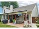 The charming covered patio offers outdoor living space with comfortable seating and a TV at 207 Spaniel Se Dr, Concord, NC 28025