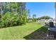 Expansive backyard with lush green grass, mature trees, and a peaceful pond at 2527 Linhay Dr, Charlotte, NC 28216