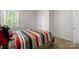 Bright bedroom featuring a window, closet, and bed with a colorful striped comforter at 2527 Linhay Dr, Charlotte, NC 28216