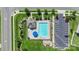 Aerial view of the community pool with parking, umbrellas, lounge chairs, and a bath house at 2527 Linhay Dr, Charlotte, NC 28216
