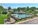 A view of the community pool with lounge chairs, umbrellas, bath house, and playground at 2527 Linhay Dr, Charlotte, NC 28216