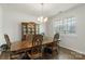 Formal dining room with a wooden hutch and table set, with natural light from the window at 2527 Linhay Dr, Charlotte, NC 28216