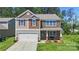 Charming two-story home with a blend of stone and siding, featuring an attached garage and well-manicured lawn at 2527 Linhay Dr, Charlotte, NC 28216