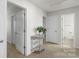 Hallway featuring multiple doors and a decorative table with a plant at 2527 Linhay Dr, Charlotte, NC 28216