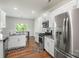 Well-lit kitchen features stainless steel appliances, white cabinets, granite counters, and hardwood floors at 2527 Linhay Dr, Charlotte, NC 28216