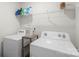 Functional laundry room equipped with a washer, dryer, and storage shelf at 2527 Linhay Dr, Charlotte, NC 28216