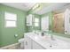 Bathroom with double vanity, large mirror, shower, and bright green walls at 2717 Aubrey St, Monroe, NC 28110