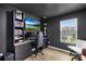 Home office features a large monitor, built-in shelving, and natural light at 2717 Aubrey St, Monroe, NC 28110