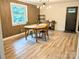 Modern dining room featuring textured accent wall, wood-look flooring, and stylish light fixture at 3115 Falling Creek Rd, Hickory, NC 28601