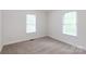 A carpeted bedroom with two windows and white trim at 328 Burrage Ne Rd, Concord, NC 28025