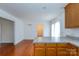 Bright kitchen featuring hardwood floors, white walls, and wood cabinetry at 328 Burrage Ne Rd, Concord, NC 28025