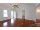 Open-concept living room with hardwood floors, ceiling fan, and ample natural light at 328 Burrage Ne Rd, Concord, NC 28025