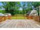 Expansive backyard view from wooden deck, featuring lush greenery and mature trees at 336 Oakwood Dr, Mount Holly, NC 28120