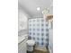 Well-lit bathroom featuring a toilet and a shower with a blue and white checkered curtain at 336 Oakwood Dr, Mount Holly, NC 28120