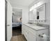 Well-lit bathroom featuring a double vanity with two mirrors and an open doorway to the bedroom at 336 Oakwood Dr, Mount Holly, NC 28120
